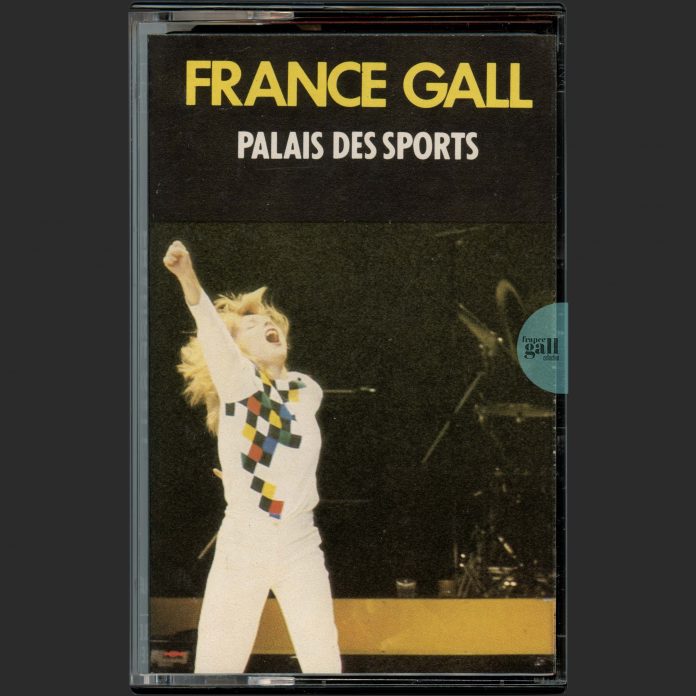 Edition au format boitier de cassette noir et étiquette papier pour la France, fabriquée en Allemagne - France Gall au Palais des Sports a été enregistré le 13 février 1982 pendant les concerts de France Gall du 7 janvier au 14 février 1982 au Palais des sports de Paris.